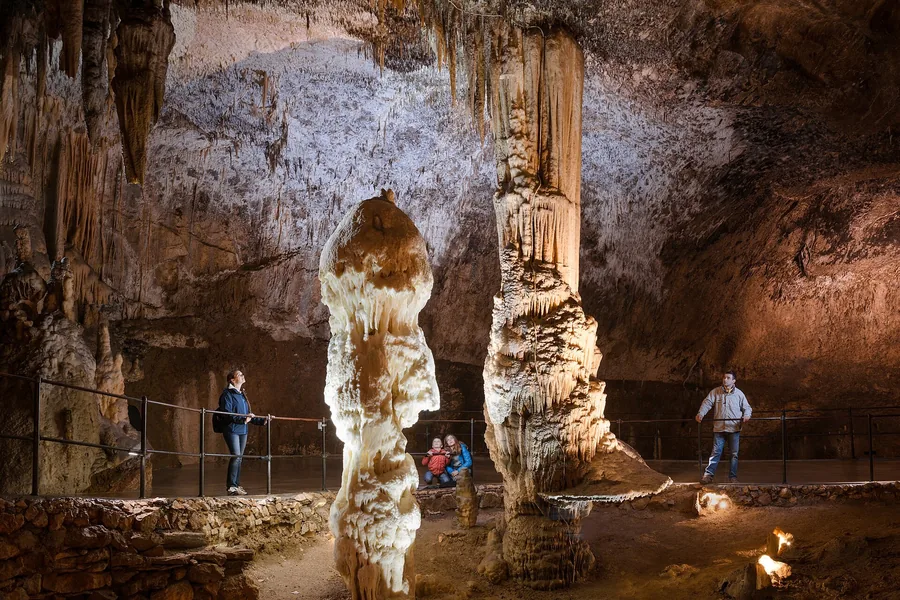 Visitors in a great illuminated hall of Postojna Cave